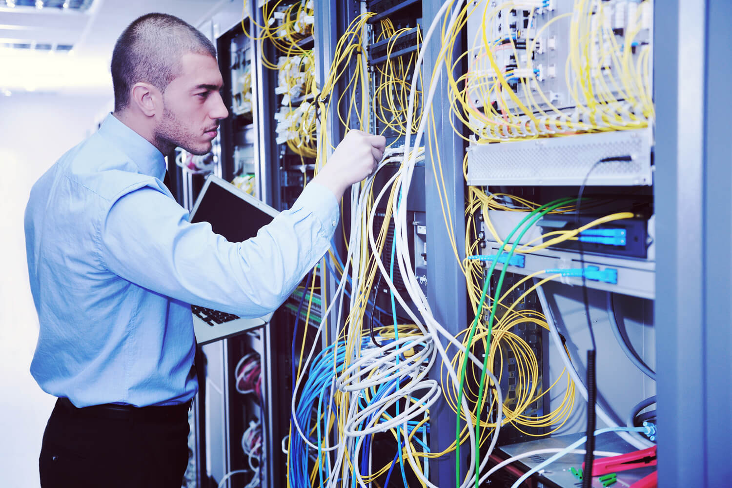 young engeneer business man with thin modern aluminium laptop in network server room