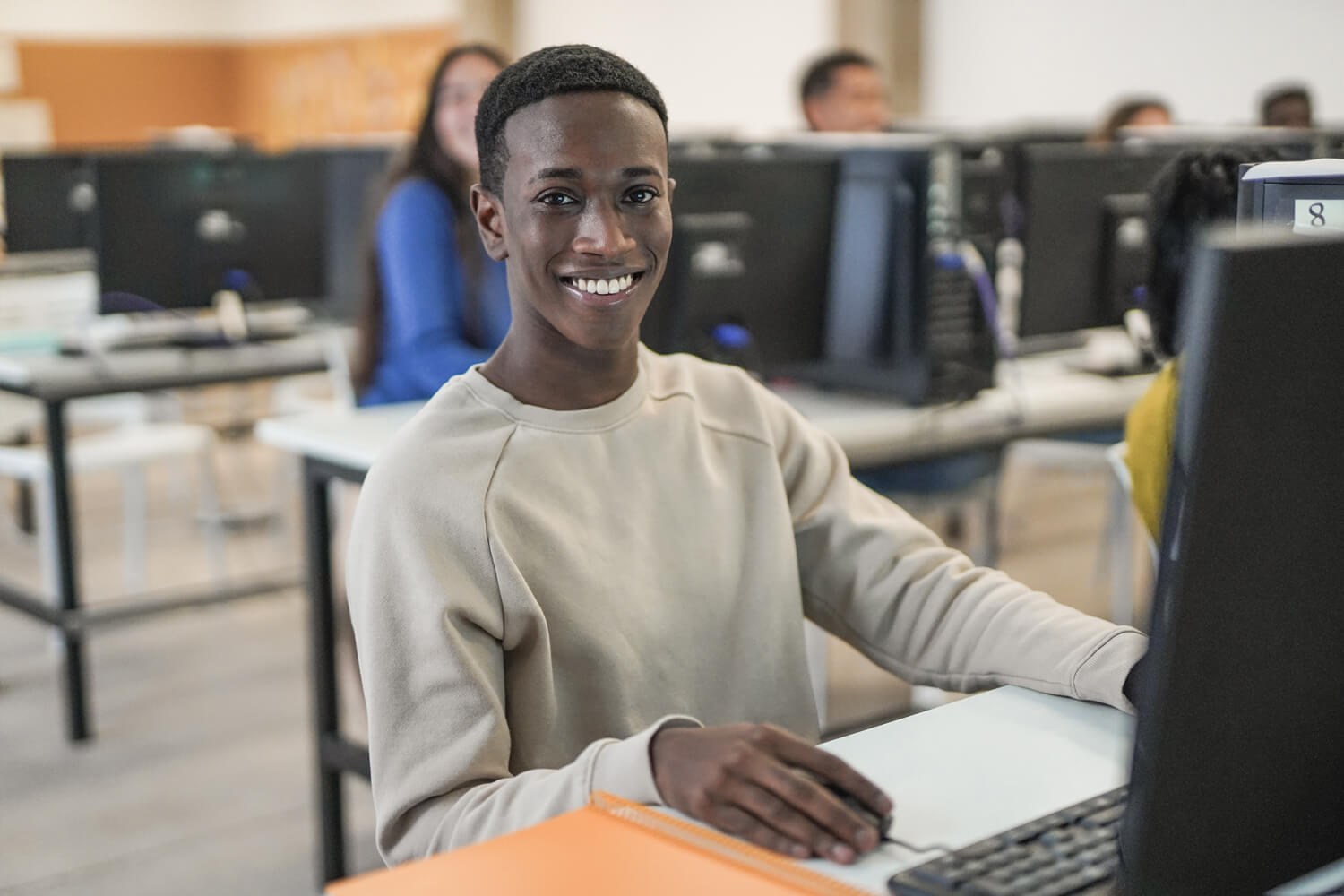 Young african boy smiling on camera inside computer class room